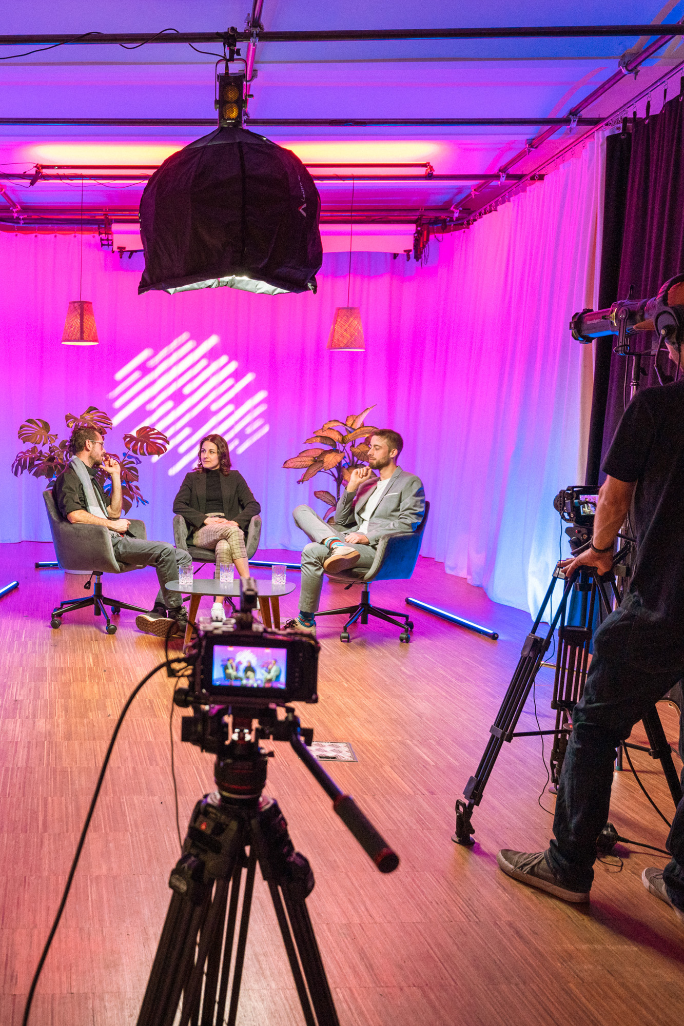 Livestreaming im boxquadrat Studio Personen vor blau rosa Hintergrund vor der Kamera im Livestreaming Studio boxquadrat Wien