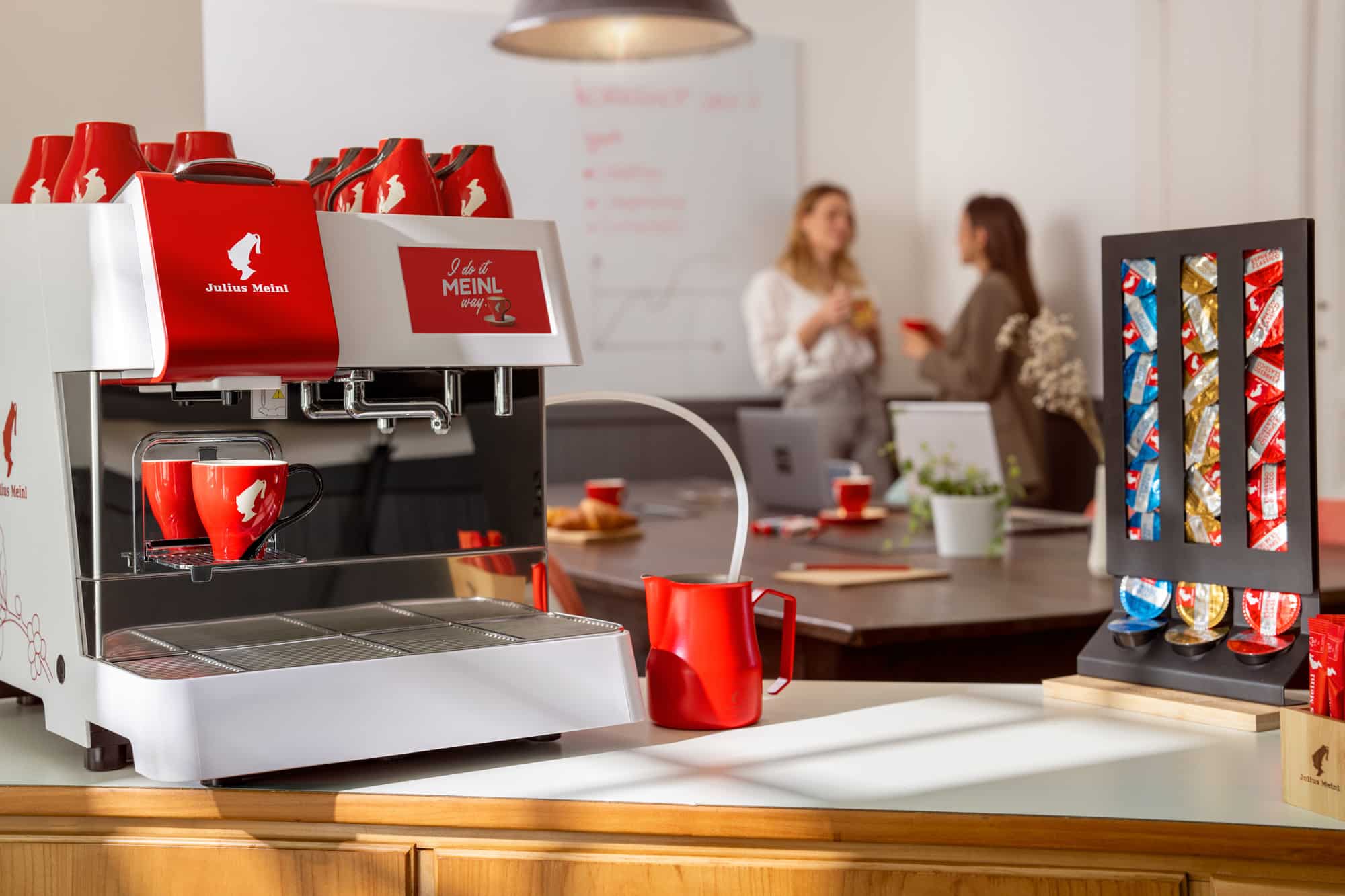 Produktfotos der Professional Capsules für Julius Meinl Kaffee. Große Kapsel Kaffeemaschiene in einem Meetingraum.