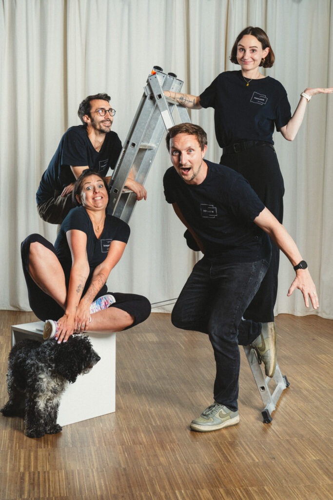 Gruppenfoto mit Lustigen Gesichtsausdruck von Jakob Grill, Philipp Schulz, Paula Sidorczuk mit Hund Mango und Lauren Klocker auf einer silbernen Leiter im boxquadrat Fotostudio