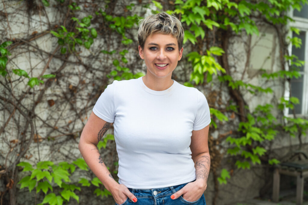 Paula Sidorczuk von boxquadrat im Porträt draußen vor einer Wand mit grünen Blättern