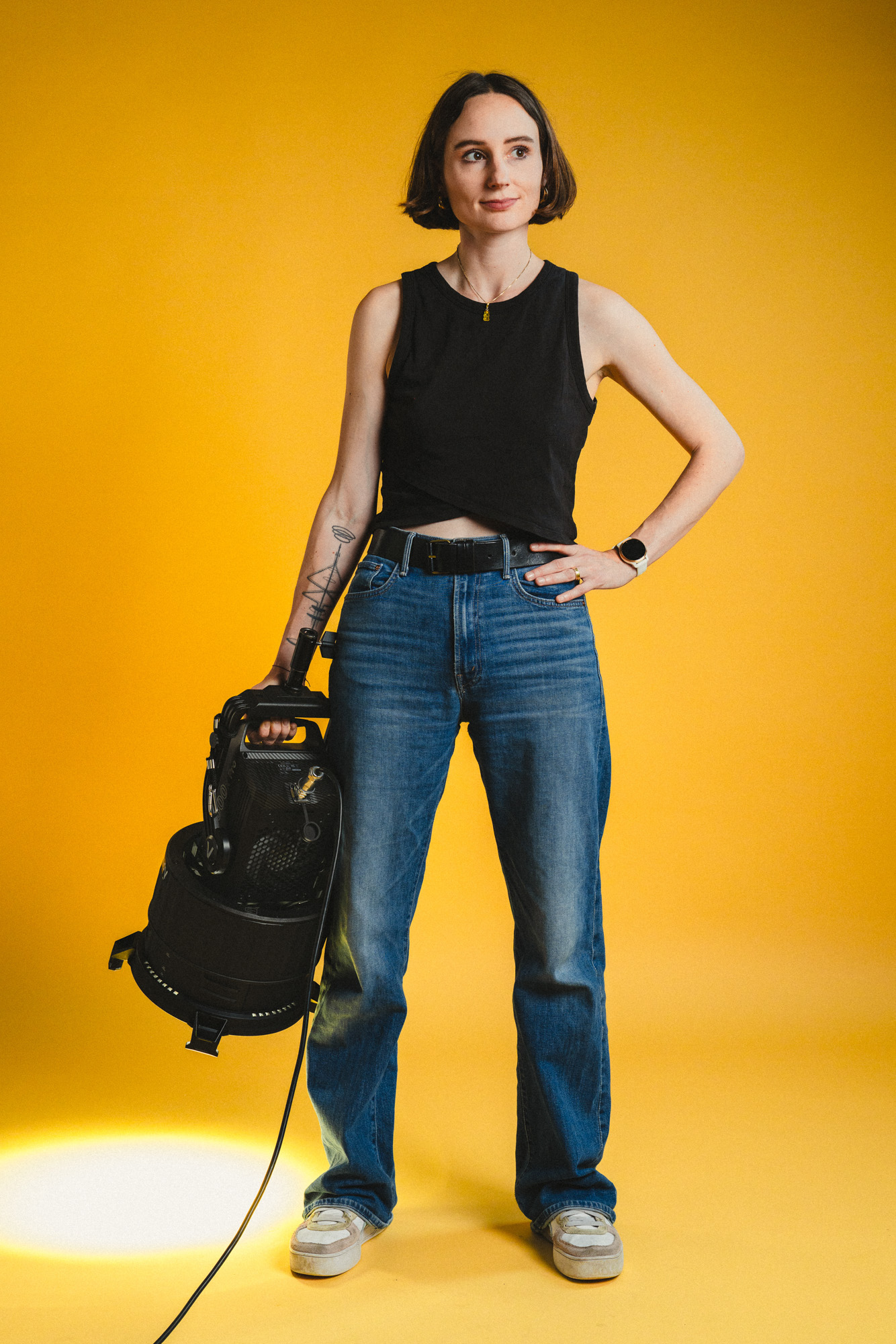Ganzkörper Foto von Lauren Klocker wegschauend, stehend mit Aputure 600x Licht in der Hand, im boxquadrat Fotostudio 1160 Wien