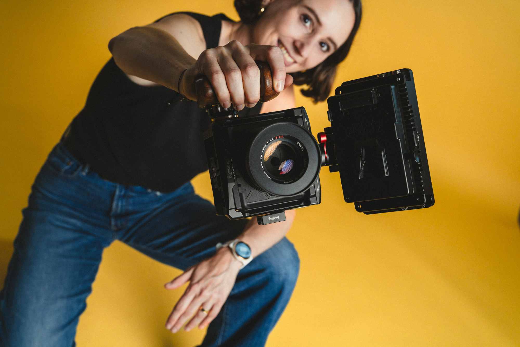 Lauren Klocker von der Content Produktion Firma boxquadrat lächelnd und sitzend mit RED Komodo Kamera in der Hand, am Boden