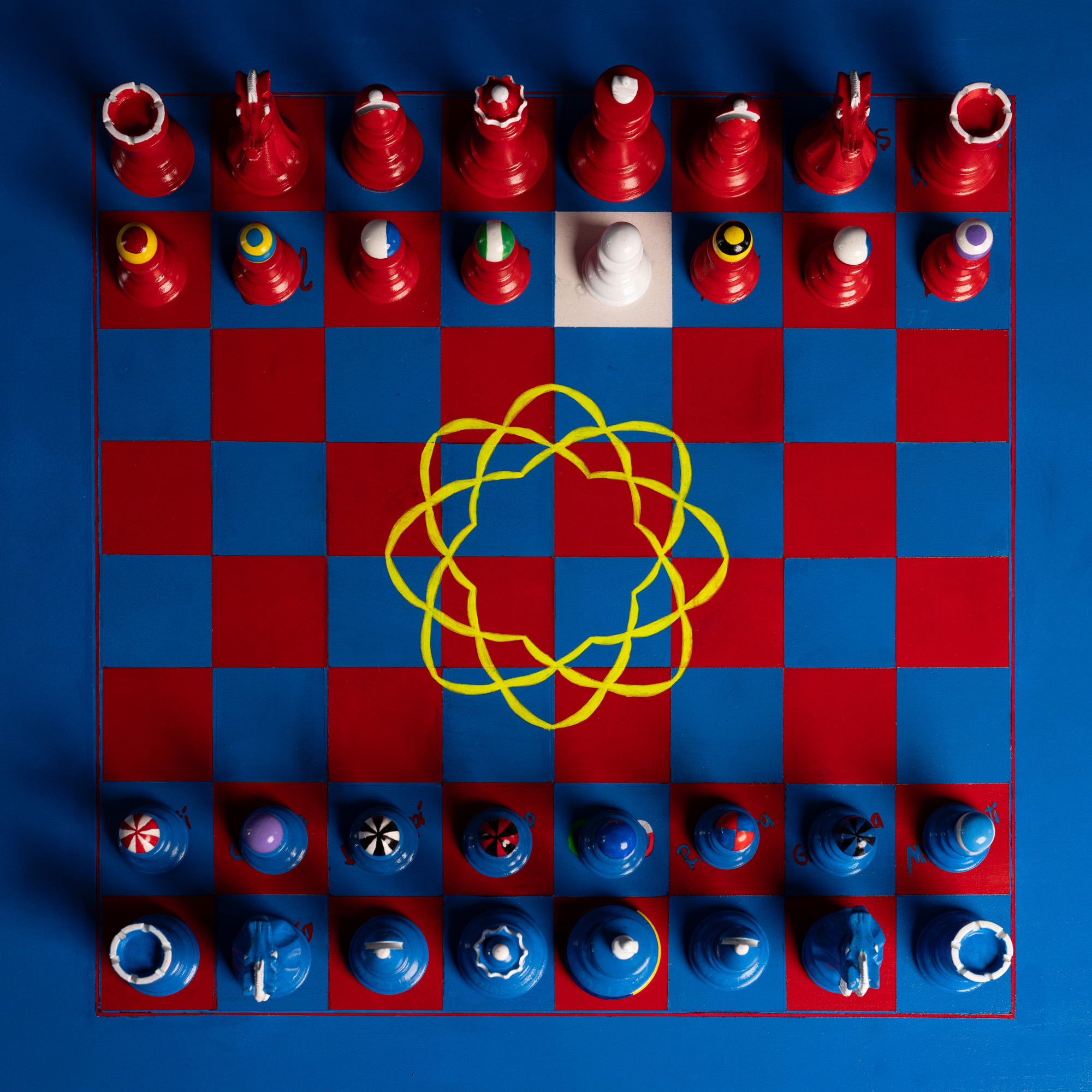 Produktfoto eines Schachbretts mit Figuren in Rot und Blau von oben
